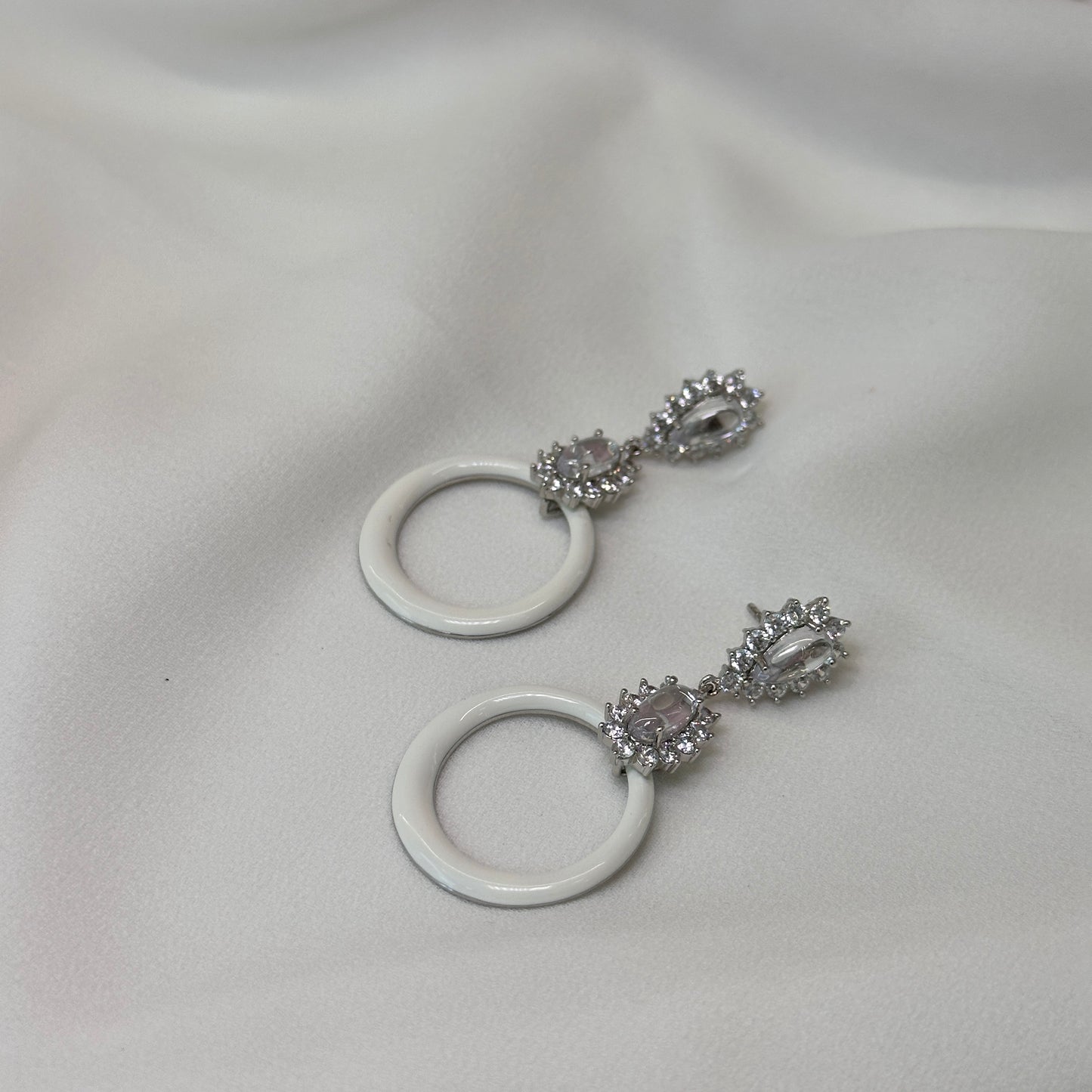 Brinco ródio alongado esmaltado branco com cristaos