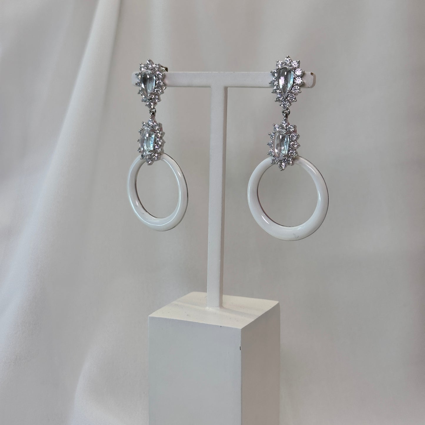 Brinco ródio alongado esmaltado branco com cristaos